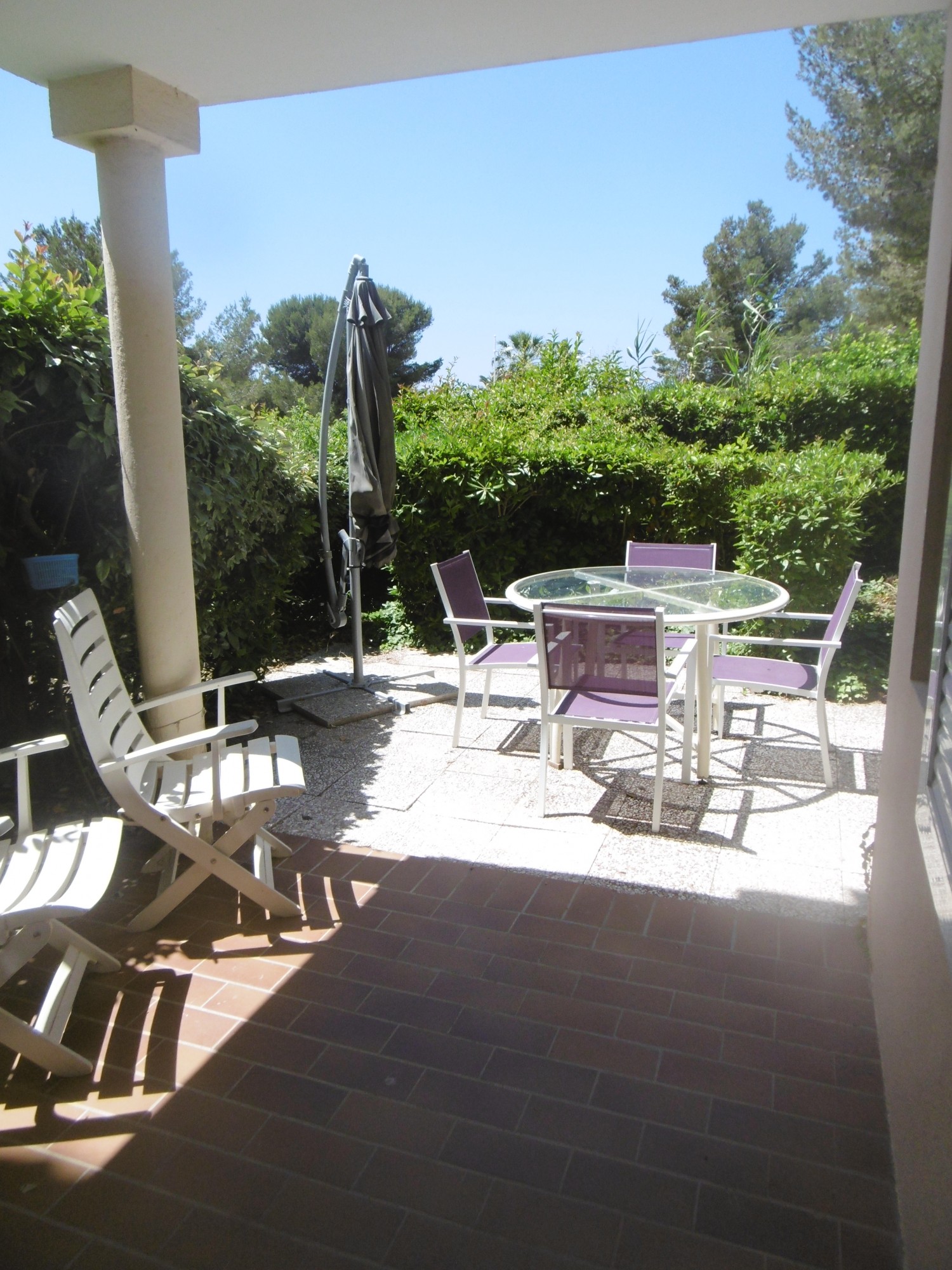 Jardin et terrasse avec salon de jardin et parasol offrant petite vue mer